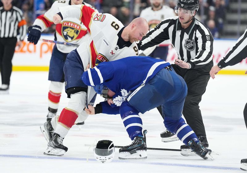 Nov 28, 2023; Toronto, Ontario, CAN; Florida Panthers center Sam Bennett (9) fights with Toronto Maple Leafs center Max Domi (11) during the second period at Scotiabank Arena. Mandatory Credit: Nick Turchiaro-USA TODAY Sports