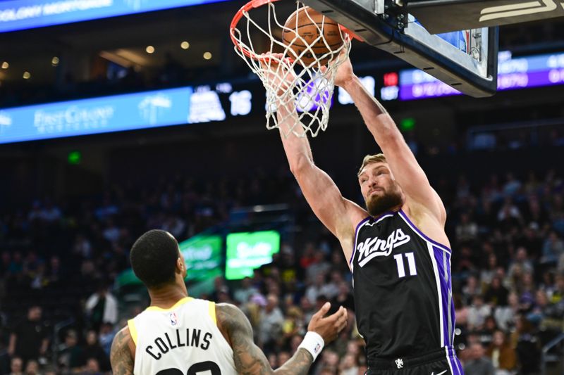 SALT LAKE CITY, UTAH - OCTOBER 15: Domantas Sabonis #11 of the Sacramento Kings dunks over John Collins #20 of the Utah Jazz during the first half of a preseason game at Delta Center on October 15, 2024 in Salt Lake City, Utah. NOTE TO USER: User expressly acknowledges and agrees that, by downloading and or using this photograph, User is consenting to the terms and conditions of the Getty Images License Agreement. (Photo by Alex Goodlett/Getty Images)