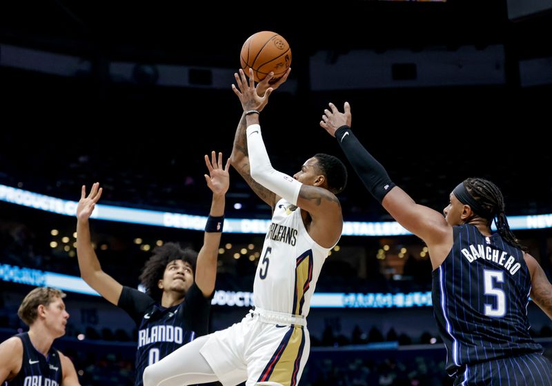 NEW ORLEANS, LOUISIANA - OCTOBER 7:  Dejounte Murray #5 of the New Orleans Pelicans shoots over Paolo Banchero #5 of the Orlando Magic and Anthony Black #0 during the first half of a preseason game at the Smoothie King Center on October 7, 2024 in New Orleans, Louisiana. NOTE TO USER: User expressly acknowledges and agrees that, by downloading and or using this photograph, User is consenting to the terms and conditions of the Getty Images License Agreement. (Photo by Derick E. Hingle/Getty Images)