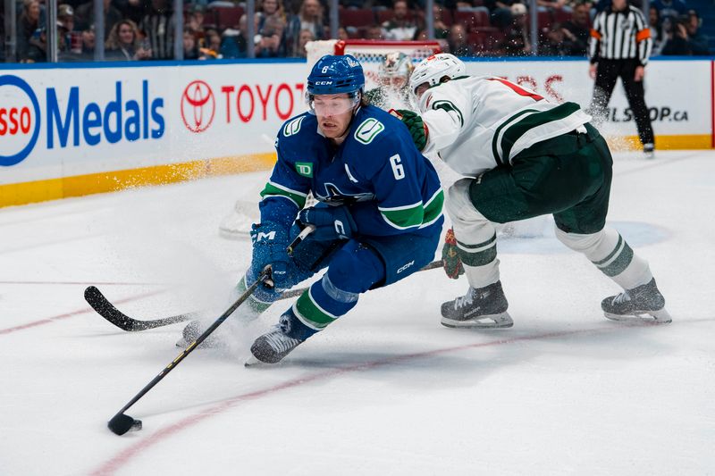 Apr 12, 2025; Vancouver, British Columbia, CAN; Minnesota Wild forward Matt Boldy (12) checks Vancouver Canucks forward Brock Boeser (6) in overtime at Rogers Arena. Mandatory Credit: Bob Frid-Imagn Images