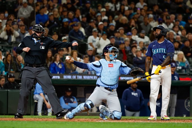 Aug 27, 2024; Seattle, Washington, USA; Seattle Mariners left fielder Randy Arozarena (56) reacts to a strike out  call by umpire Jacob Metz (94) against the Tampa Bay Rays during the eighth inning at T-Mobile Park. Tampa Bay Rays catcher Alex Jackson (28) throws the ball. Mandatory Credit: Joe Nicholson-USA TODAY Sports