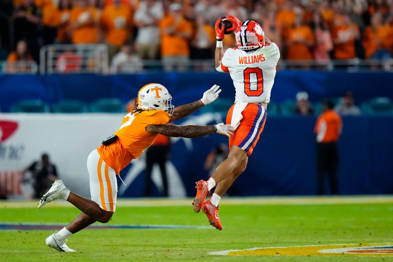 Dec 30, 2022; Miami Gardens, FL, USA; Clemson Tigers wide receiver Antonio Williams (0) catches a pass while defended by Tennessee Volunteers defensive back Jaylen McCollough (2) during the first quarter of the 2022 Orange Bowl at Hard Rock Stadium. Mandatory Credit: Rich Storry-USA TODAY Sports