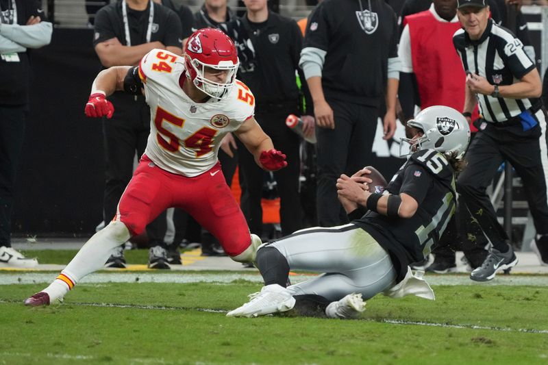 Las Vegas Raiders quarterback Gardner Minshew (15) slides for yardage as Kansas City Chiefs linebacker Leo Chenal (54) defends during the second half of an NFL football game Sunday, Oct. 27, 2024, in Las Vegas. (AP Photo/Rick Scuteri)