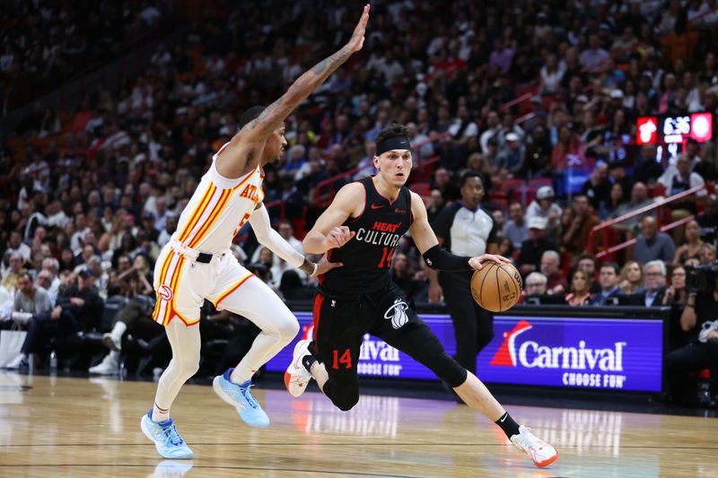 MIAMI, FLORIDA - JANUARY 19: Tyler Herro #14 of the Miami Heat drives against Dejounte Murray #5 of the Atlanta Hawks during the fourth quarter of the game at Kaseya Center on January 19, 2024 in Miami, Florida. NOTE TO USER: User expressly acknowledges and agrees that, by downloading and or using this photograph, User is consenting to the terms and conditions of the Getty Images License Agreement. (Photo by Megan Briggs/Getty Images)