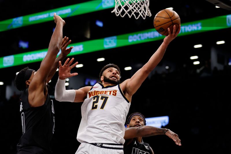 NEW YORK, NEW YORK - DECEMBER 22: Jamal Murray #27 of the Denver Nuggets goes to the basket as Day'Ron Sharpe #20 and Royce O'Neale #00 of the Brooklyn Nets defend during the second half at Barclays Center on December 22, 2023 in the Brooklyn borough of New York City. The Nuggets won 122-117. NOTE TO USER: User expressly acknowledges and agrees that, by downloading and/or using this Photograph, user is consenting to the terms and conditions of the Getty Images License Agreement. (Photo by Sarah Stier/Getty Images)