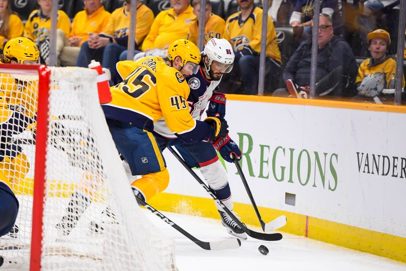 Apr 13, 2024; Nashville, Tennessee, USA; Nashville Predators defenseman Alexandre Carrier (45) and Columbus Blue Jackets right wing Kirill Marchenko (86) fight for the puck during the second period at Bridgestone Arena. Mandatory Credit: Steve Roberts-USA TODAY Sports