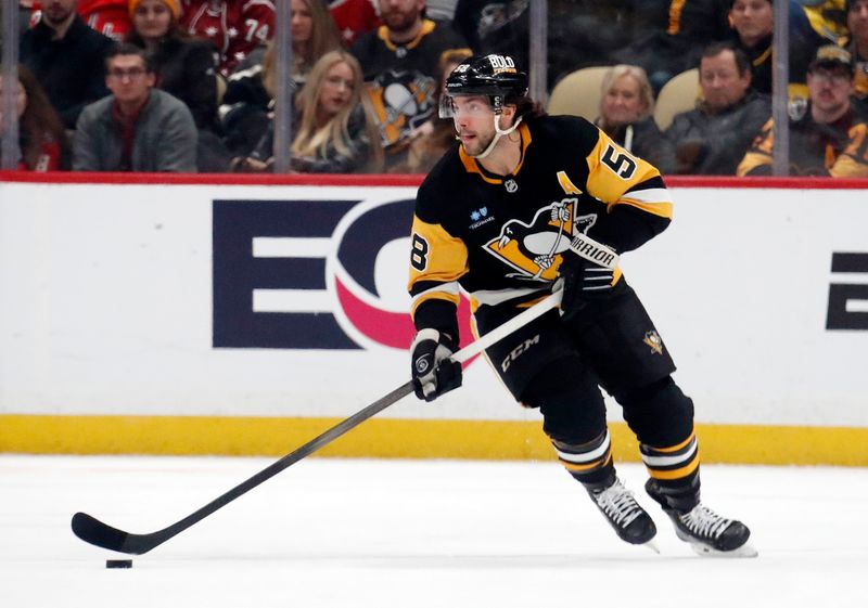 Jan 2, 2024; Pittsburgh, Pennsylvania, USA;  Pittsburgh Penguins defenseman Kris Letang (58) moves the puck against the Washington Capitals during the first period at PPG Paints Arena. Mandatory Credit: Charles LeClaire-USA TODAY Sports