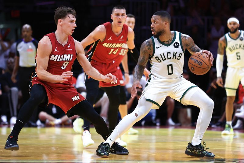 MIAMI, FLORIDA - NOVEMBER 26: Damian Lillard #0 of the Milwaukee Bucks dribbles the ball against Pelle Larsson #9 of the Miami Heat during the third quarter  at Kaseya Center on November 26, 2024 in Miami, Florida. NOTE TO USER: User expressly acknowledges and agrees that, by downloading and or using this photograph, User is consenting to the terms and conditions of the Getty Images License Agreement. (Photo by Megan Briggs/Getty Images)