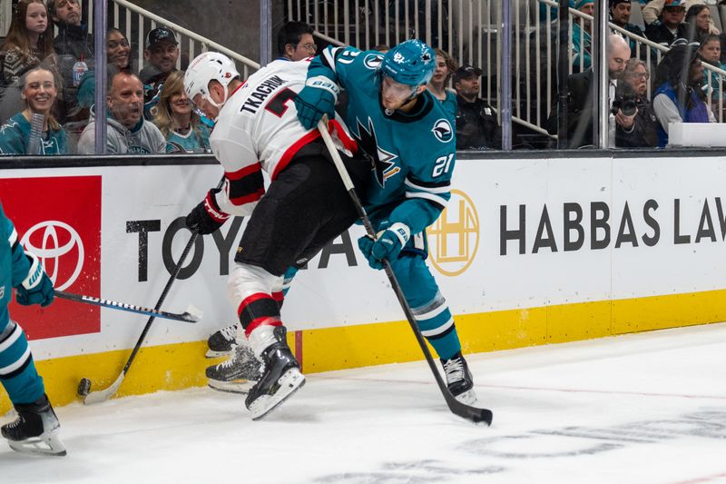 Nov 27, 2024; San Jose, California, USA; San Jose Sharks center Alexander Wennberg (21) and Ottawa Senators left wing Brady Tkachuk (7) battle for the puck against the boards during the first period at SAP Center at San Jose. Mandatory Credit: Neville E. Guard-Imagn Images