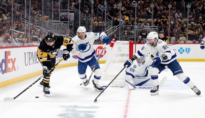 Apr 6, 2024; Pittsburgh, Pennsylvania, USA;  Pittsburgh Penguins right wing Rickard Rakell (67) moves the puck against Tampa Bay Lightning defenseman Darren Raddysh (43) and goaltender Andrei Vasilevskiy (88) and right wing Nikita Kucherov (86) during the third period at PPG Paints Arena. The Penguins won 5-4. Mandatory Credit: Charles LeClaire-USA TODAY Sports