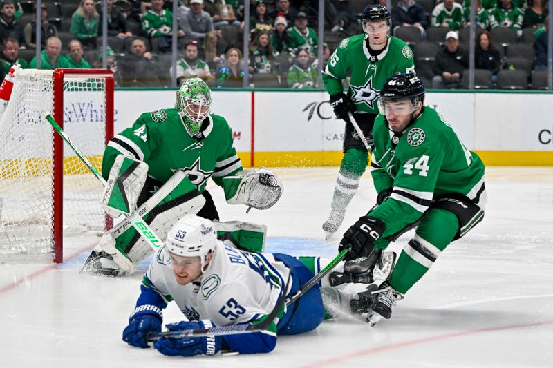 Dec 21, 2023; Dallas, Texas, USA; Vancouver Canucks center Teddy Blueger (53) is tripped up in front of Dallas Stars goaltender Scott Wedgewood (41) and defenseman Joel Hanley (44) as he tires to control the puck during the first period at the American Airlines Center. Mandatory Credit: Jerome Miron-USA TODAY Sports