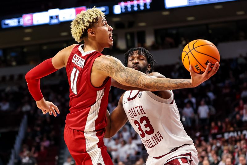 Feb 4, 2023; Columbia, South Carolina, USA; Arkansas Razorbacks forward Jalen Graham (11) drives around South Carolina Gamecocks forward Josh Gray (33) in the first half at Colonial Life Arena. Mandatory Credit: Jeff Blake-USA TODAY Sports