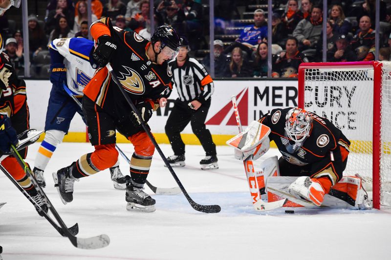 Apr 7, 2024; Anaheim, California, USA; Anaheim Ducks goaltender Lukas Dostal (1) covers the puck as defenseman Cam Fowler (4) helps defend the goal against the St. Louis Blues during the third period at Honda Center. Mandatory Credit: Gary A. Vasquez-USA TODAY Sports