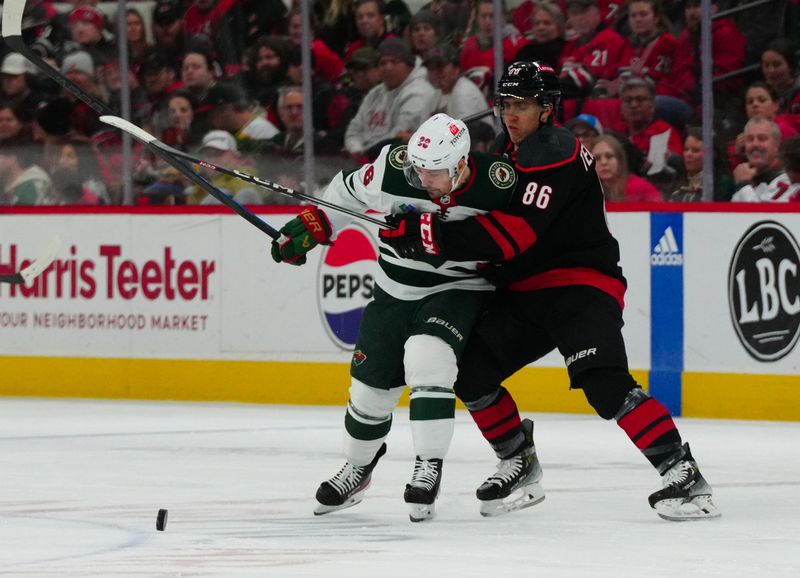 Jan 21, 2024; Raleigh, North Carolina, USA;  Carolina Hurricanes left wing Teuvo Teravainen (86) and Minnesota Wild right wing Mats Zuccarello (36) battle over the puck during the third period at PNC Arena. Mandatory Credit: James Guillory-USA TODAY Sports