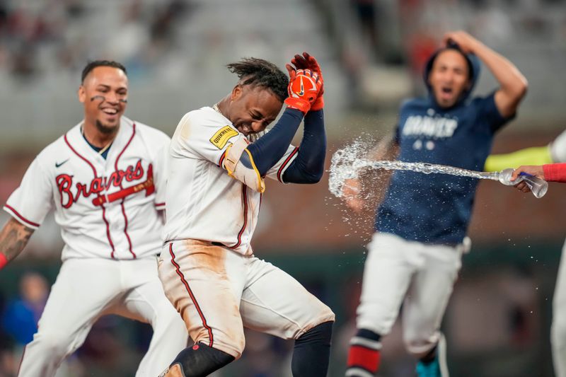 Sep 27, 2023; Cumberland, Georgia, USA; Atlanta Braves second baseman Ozzie Albies (1) gets splashed with water by teammates after getting the game winning hit against the Chicago Cubs during the tenth inning at Truist Park. Mandatory Credit: Dale Zanine-USA TODAY Sports