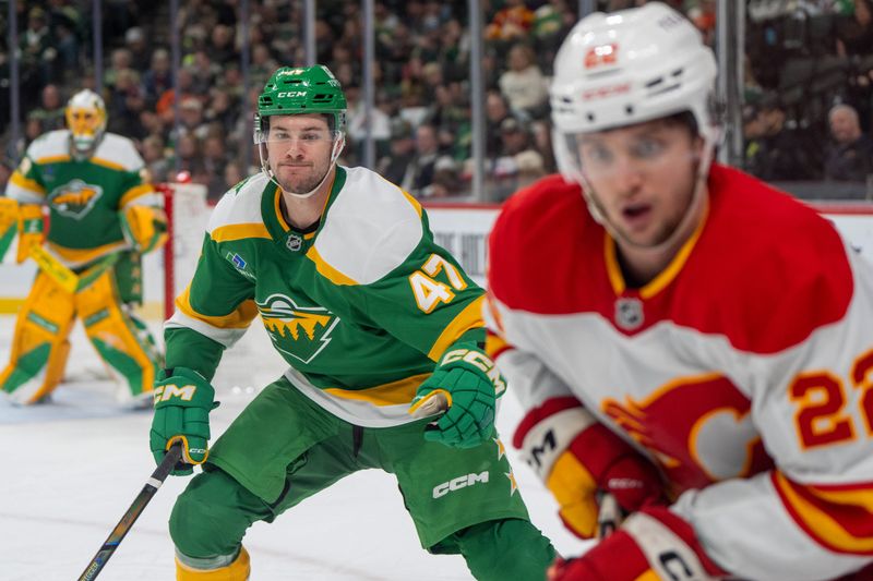 Jan 25, 2025; Saint Paul, Minnesota, USA; Minnesota Wild defenseman Declan Chisholm (47) pursues Calgary Flames left wing Jakob Pelletier (22) in the third period at Xcel Energy Center. Mandatory Credit: Matt Blewett-Imagn Images