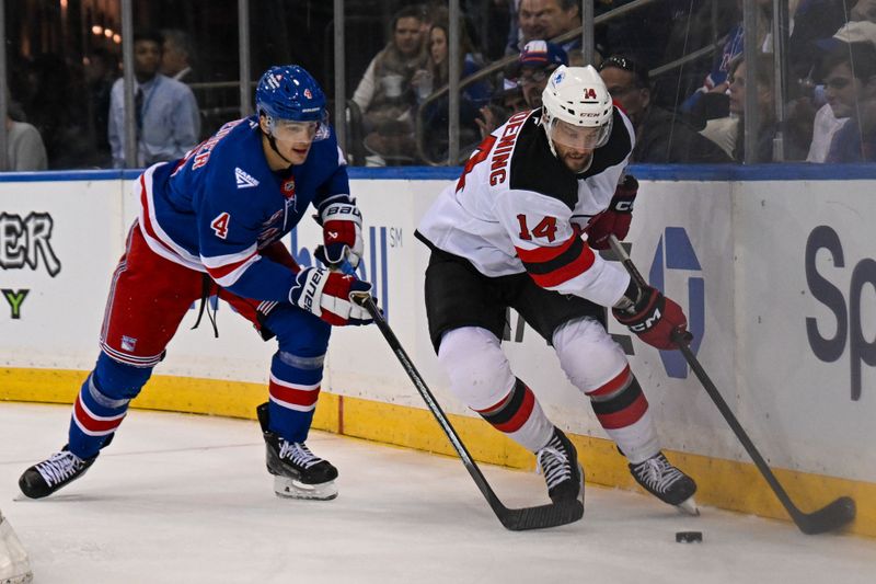 Oct 2, 2025; New York, New York, USA;  New Jersey Devils forward Luke Glendening (14) and New York Rangers defenseman Braden Schneider (4) battle for the puck behind the net during the first period at Madison Square Garden. Mandatory Credit: Dennis Schneidler-Imagn Images