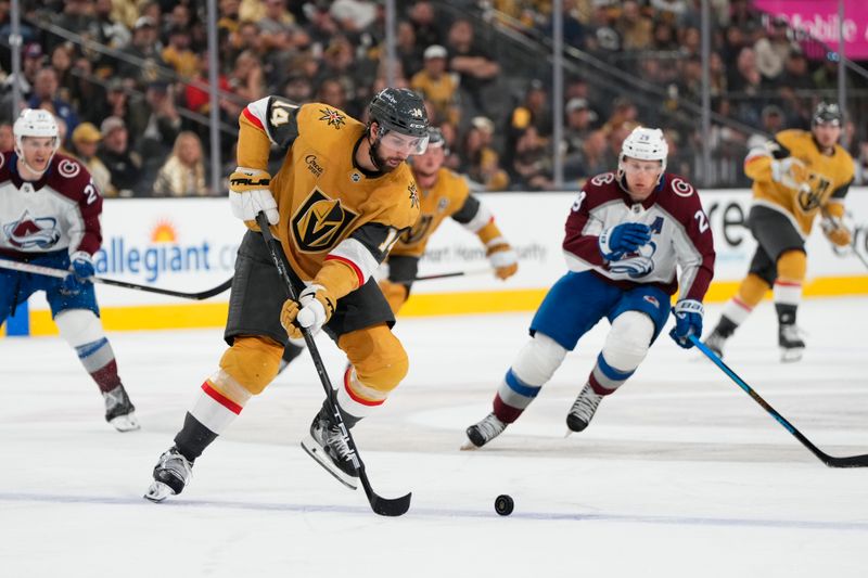 Oct 9, 2024; Las Vegas, Nevada, USA; Vegas Golden Knights defenseman Nicolas Hague (14) skates with the puck against Colorado Avalanche center Nathan MacKinnon (29) during the third period at T-Mobile Arena. Mandatory Credit: Lucas Peltier-Imagn Images