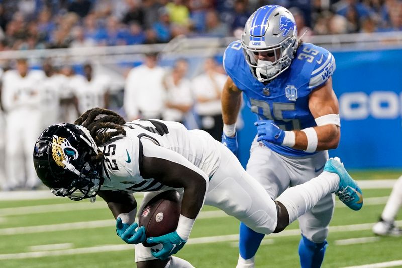 Jacksonville Jaguars running back D'Ernest Johnson (25) makes a catch against Detroit Lions safety Brady Breeze (35) during the second half of a preseason NFL football game, Saturday, Aug. 19, 2023, in Detroit. (AP Photo/Paul Sancya)