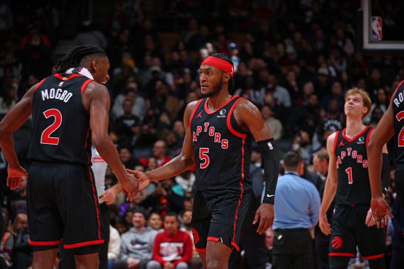 TORONTO, CANADA - FEBRUARY 23: Jonathan Mogbo #2 and Immanuel Quickley #5 of the Toronto Raptors high five during the game against the Phoenix Suns on February 23, 2025 at the Scotiabank Arena in Toronto, Ontario, Canada.  NOTE TO USER: User expressly acknowledges and agrees that, by downloading and or using this Photograph, user is consenting to the terms and conditions of the Getty Images License Agreement.  Mandatory Copyright Notice: Copyright 2025 NBAE (Photo by Vaughn Ridley/NBAE via Getty Images)