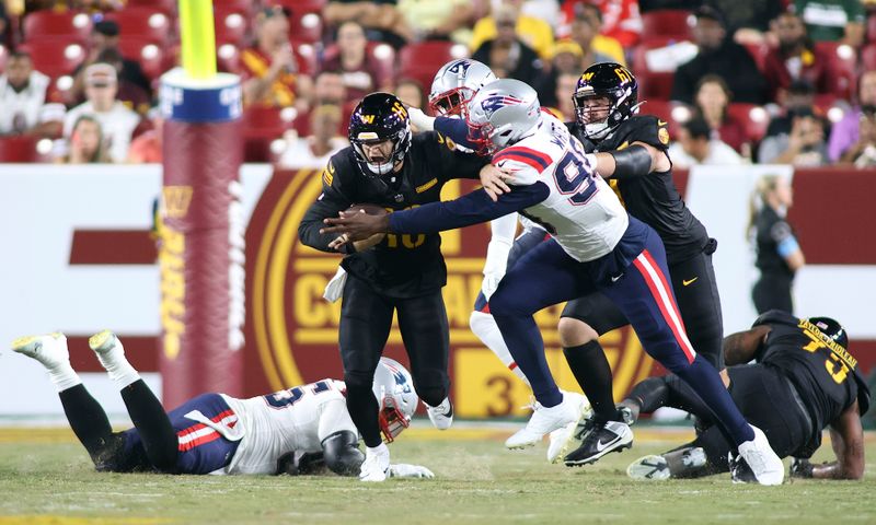 Washington Commanders quarterback Jeff Driskel (16) gets taken down for a sack during an NFL football game against the New England Patriots, Sunday, August 25, 2024 in Landover, Md. (AP Photo/Daniel Kucin Jr.)
