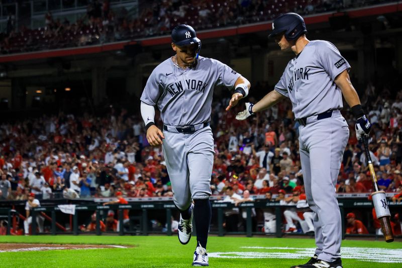 Jun 24, 2025; Cincinnati, Ohio, USA; New York Yankees outfielder Aaron Judge (99) high fives second baseman DJ LeMahieu (26) after scoring on a wild pitch by Cincinnati Reds relief pitcher Connor Phillips (not pictured) in the eleventh inning at Great American Ball Park. Mandatory Credit: Katie Stratman-Imagn Images