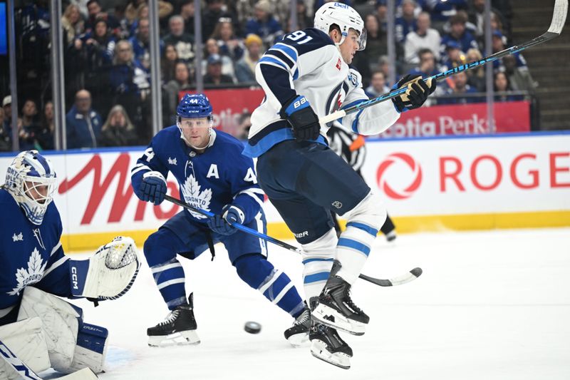 Jan 1, 2026; Toronto, Ontario, CAN;  Winnipeg Jets forward Cole Perfetti (91) leaps to avoid a shot on Toronto Maple Leafs goalie Dennis Hildeby (35) in the second period at Scotiabank Arena. Mandatory Credit: Dan Hamilton-Imagn Images