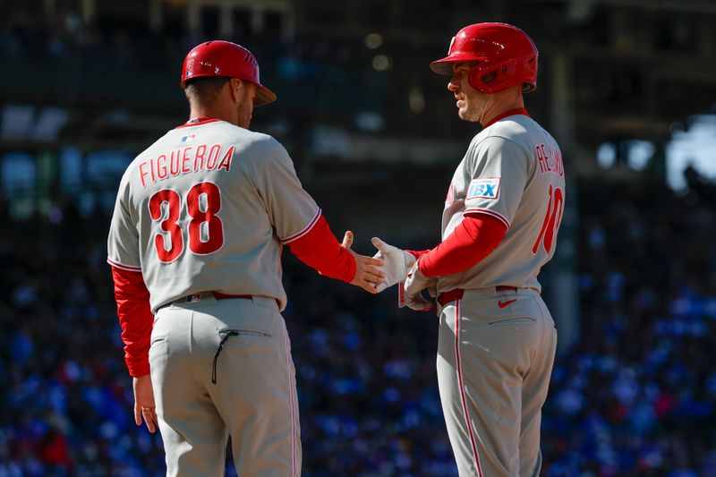 Apr 26, 2025; Chicago, Illinois, USA; Philadelphia Phillies catcher J.T. Realmuto (10) celebrates with first base coach Paco Figueroa (38) after hitting a single against the Chicago Cubs during the fourth inning at Wrigley Field. Mandatory Credit: Kamil Krzaczynski-Imagn Images
