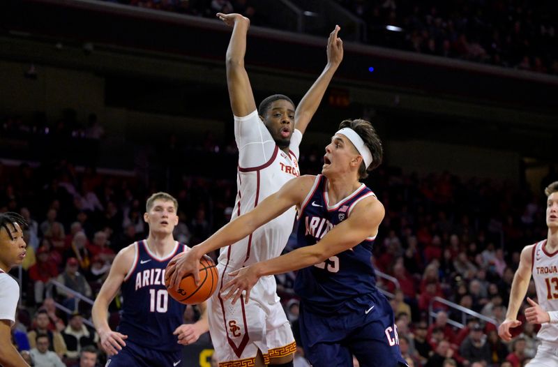 Mar 2, 2023; Los Angeles, California, USA; Arizona Wildcats guard Kerr Kriisa (25) passes the ball around USC Trojans forward Joshua Morgan (24) to Arizona Wildcats forward Azuolas Tubelis (10) in the second half at Galen Center. Mandatory Credit: Jayne Kamin-Oncea-USA TODAY Sports