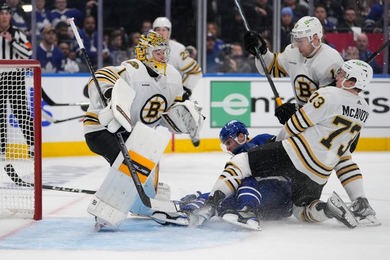 Apr 24, 2024; Toronto, Ontario, CAN; Boston Bruins goaltender Jeremy Swayman (1) looks for the puck as defenseman Charlie McAvoy (73) and forward Charlie Coyle (13) take Toronto Maple Leafs forward John Tavares (91) into the net during the third period of game three of the first round of the 2024 Stanley Cup Playoffs at Scotiabank Arena. Mandatory Credit: John E. Sokolowski-USA TODAY Sports