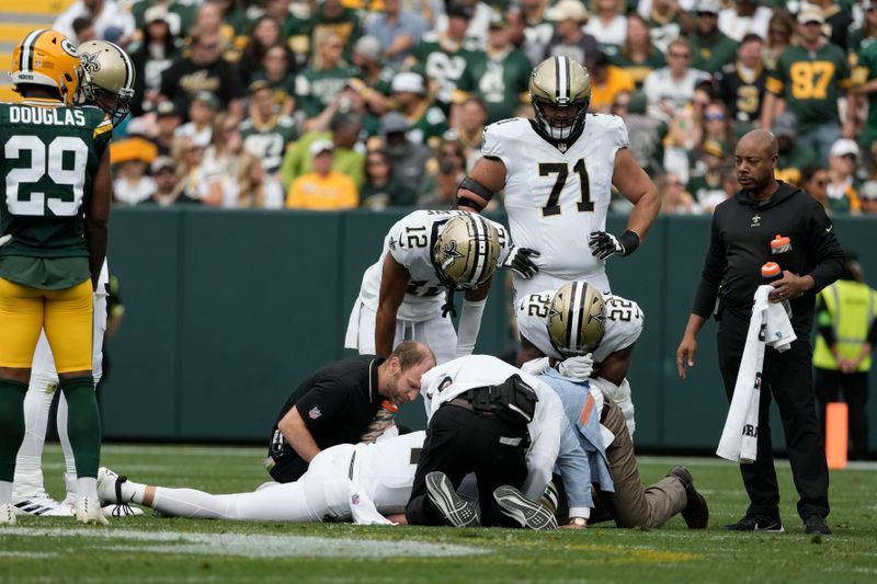 New Orleans Saints quarterback Derek Carr is tended to after being hurt during the second half of an NFL football game against the Green Bay Packers Sunday, Sept. 24, 2023, in Green Bay, Wis. (AP Photo/Morry Gash)