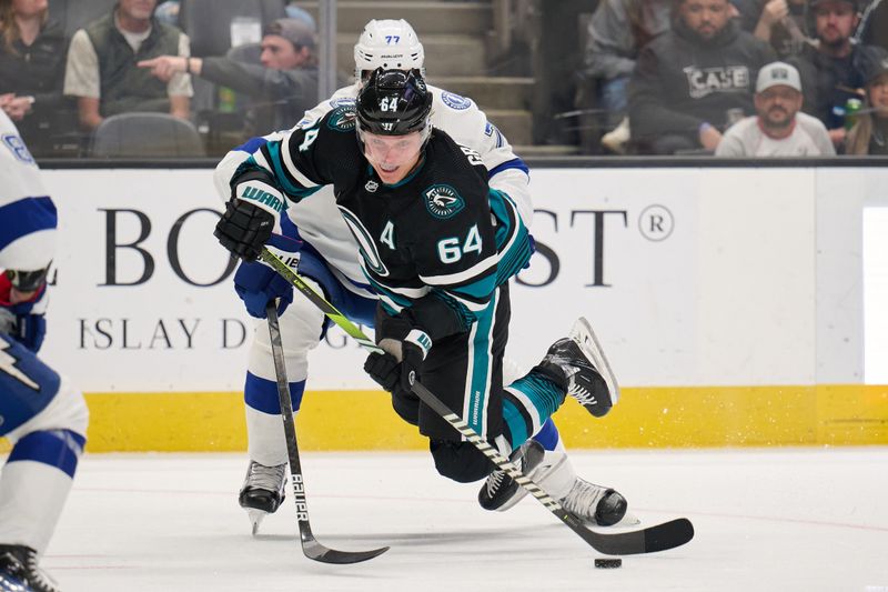 Mar 21, 2024; San Jose, California, USA; San Jose Sharks center Mikael Granlund (64) plays the puck against Tampa Bay Lightning defenseman Victor Hedman (77) during the second period at SAP Center at San Jose. Mandatory Credit: Robert Edwards-USA TODAY Sports