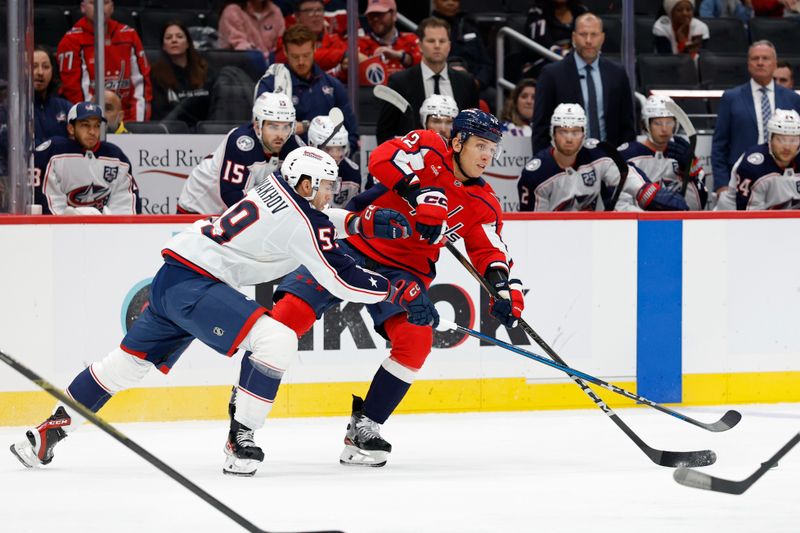Oct 4, 2025; Washington, District of Columbia, USA; Washington Capitals defenseman Martin Fehérváry (42) passes the puck against as Columbus Blue Jackets right wing Yegor Chinakhov (59) defends during the first period at Capital One Arena. Mandatory Credit: Geoff Burke-Imagn Images