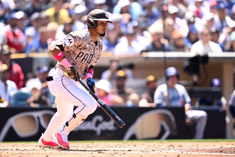 May 12, 2024; San Diego, California, USA; San Diego Padres designated hitter Luis Arraez (4) hits a double against the Los Angeles Dodgers during the second inning at Petco Park. Mandatory Credit: Orlando Ramirez-USA TODAY Sports