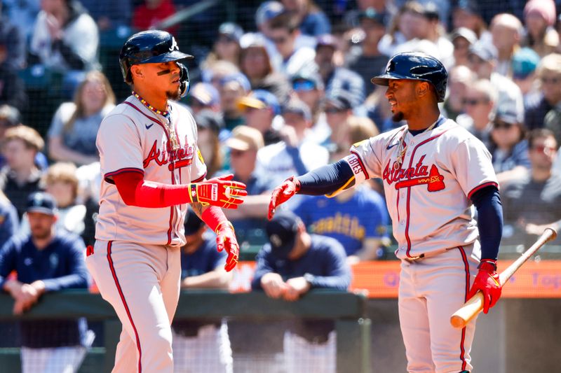 May 1, 2024; Seattle, Washington, USA; Atlanta Braves shortstop Orlando Arcia (11, left) celebrates with second baseman Ozzie Albies (1) after scoring a run against the Seattle Mariners during the fourth inning at T-Mobile Park. Mandatory Credit: Joe Nicholson-USA TODAY Sports