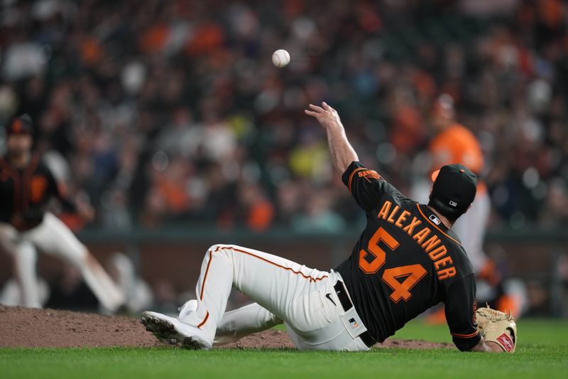 Jun 3, 2023; San Francisco, California, USA;  San Francisco Giants relief pitcher Scott Alexander (54) throws the ball to first base after falling to the ground during the eighth inning against the Baltimore Orioles at Oracle Park. Mandatory Credit: Darren Yamashita-USA TODAY Sports