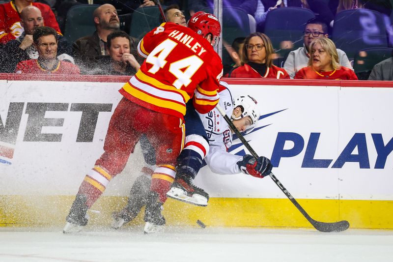 Jan 28, 2025; Calgary, Alberta, CAN; Washington Capitals left wing Andrew Mangiapane (88) and Calgary Flames defenseman Joel Hanley (44) battles for the puck during the third period at Scotiabank Saddledome. Mandatory Credit: Sergei Belski-Imagn Images