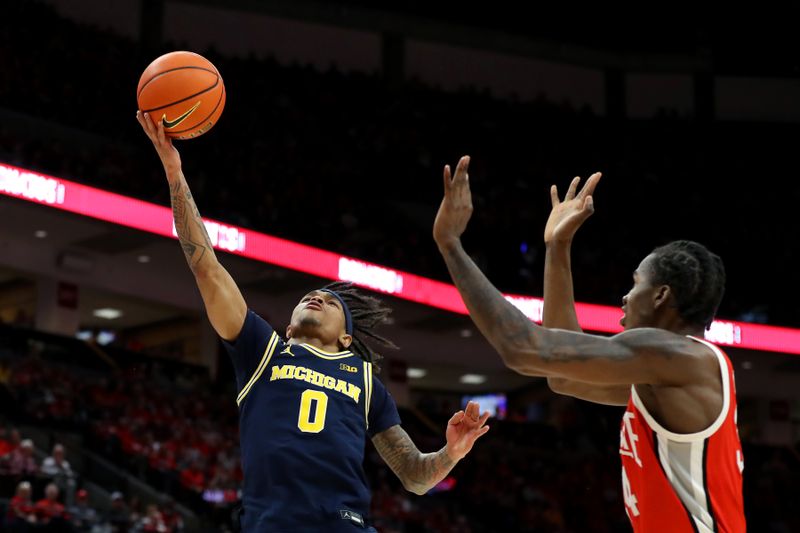 Mar 3, 2024; Columbus, Ohio, USA; Michigan Wolverines guard Dug McDaniel (0) drives to the basket as Ohio State Buckeyes center Felix Okpara (34) defends during the first half at Value City Arena. Mandatory Credit: Joseph Maiorana-USA TODAY Sports