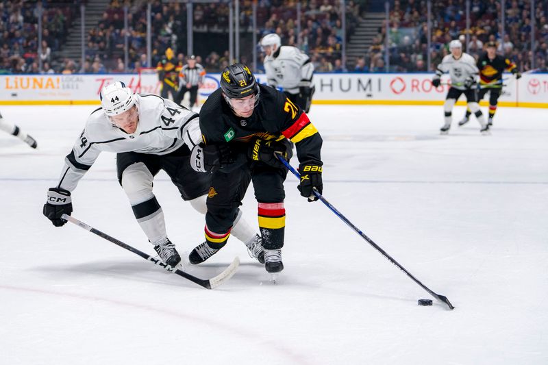 Mar 25, 2024; Vancouver, British Columbia, CAN; Vancouver Canucks forward Nils Hoglander (21) drives past Los Angeles Kings defenseman Mikey Anderson (44) in the first period at Rogers Arena. Mandatory Credit: Bob Frid-USA TODAY Sports