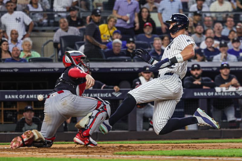 Jun 5, 2024; Bronx, New York, USA; New York Yankees center fielder Aaron Judge (99) slides safely past Minnesota Twins catcher Ryan Jeffers (27) for a run during the fifth inning at Yankee Stadium. Mandatory Credit: Vincent Carchietta-USA TODAY Sports