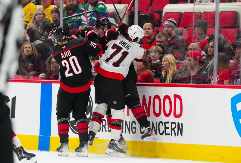 Nov 16, 2024; Raleigh, North Carolina, USA;  Ottawa Senators center Ridly Greig (71) checks Carolina Hurricanes right wing Andrei Svechnikov (37) during the third period at Lenovo Center. Mandatory Credit: James Guillory-Imagn Images