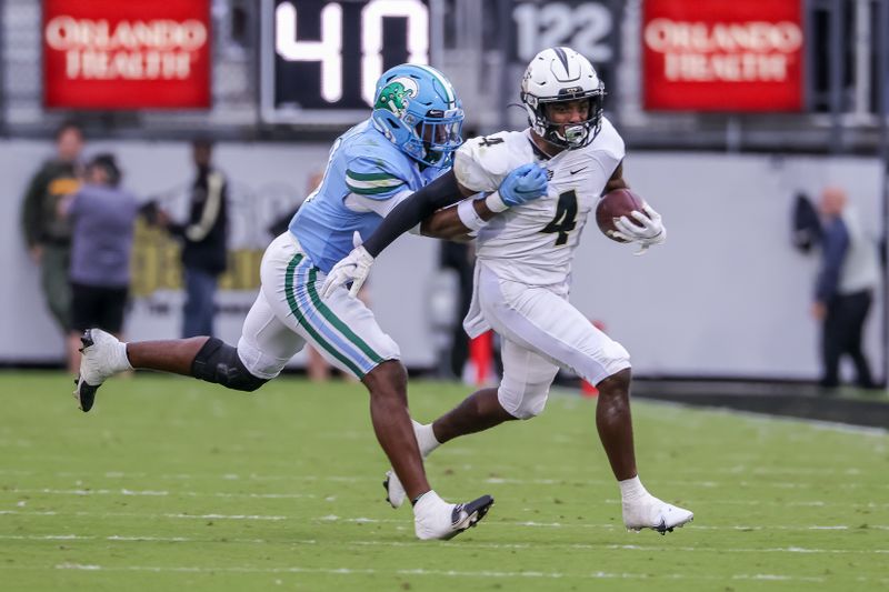 Nov 6, 2021; Orlando, Florida, USA; UCF Knights wide receiver Ryan O'Keefe (4) runs the ball against Tulane Green Wave safety Larry Brooks (31) during the second quarter at Bounce House. Mandatory Credit: Mike Watters-USA TODAY Sports