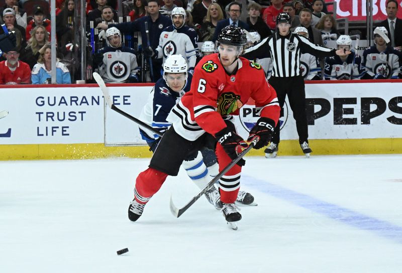 Apr 12, 2025; Chicago, Illinois, USA;  Chicago Blackhawks defenseman Sam Rinzel (6) and Winnipeg Jets center Vladislav Namestnikov (7) chase the puck during the first period at United Center. Mandatory Credit: Matt Marton-Imagn Images