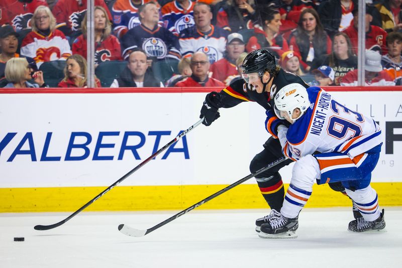 Apr 6, 2024; Calgary, Alberta, CAN; Calgary Flames left wing Dryden Hunt (15) and Edmonton Oilers center Ryan Nugent-Hopkins (93) battles for the puck during the second period at Scotiabank Saddledome. Mandatory Credit: Sergei Belski-USA TODAY Sports