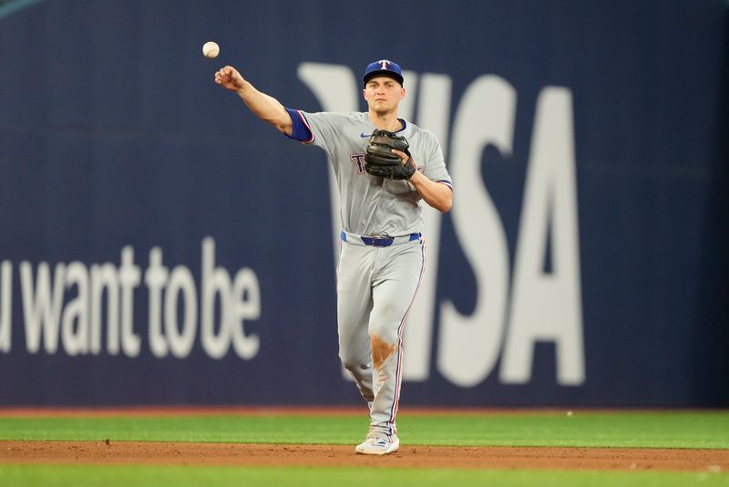 Jul 26, 2024; Toronto, Ontario, CAN; Texas Rangers shortstop Corey Seager (5) throws out Toronto Blue Jays left fielder Davis Schneider (not pictured) at first base during the sixth inning at Rogers Centre. Mandatory Credit: John E. Sokolowski-USA TODAY Sports