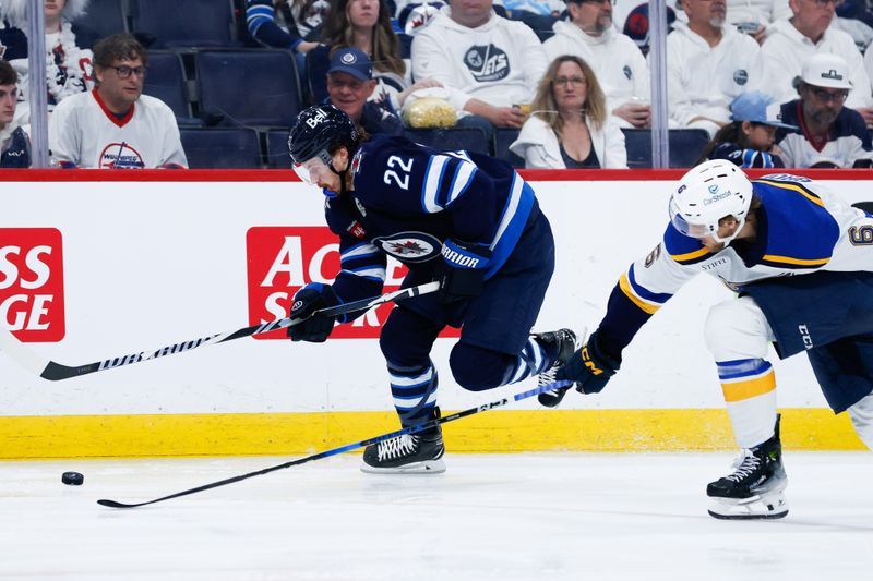 Apr 30, 2025; Winnipeg, Manitoba, CAN; Winnipeg Jets forward Mason Appleton (22) tries to skate away from St. Louis Blues defenseman Philip Broberg (6) during the second period in game five of the first round of the 2025 Stanley Cup Playoffs at Canada Life Centre. Mandatory Credit: Terrence Lee-Imagn Images