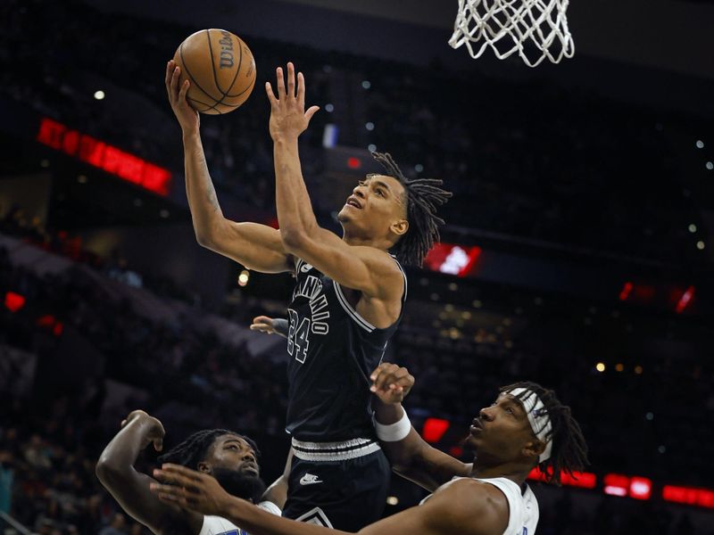 SAN ANTONIO, TX - MARCH 14: Devin Vassell #24 of the San Antonio Spurs goes to the basket for two points past Wendell Carter Jr.#34 of the Orlando Magic in the first half at AT&T Center on March 14, 2023 in San Antonio, Texas. NOTE TO USER: User expressly acknowledges and agrees that, by downloading and or using this photograph, User is consenting to terms and conditions of the Getty Images License Agreement. (Photo by Ronald Cortes/Getty Images)