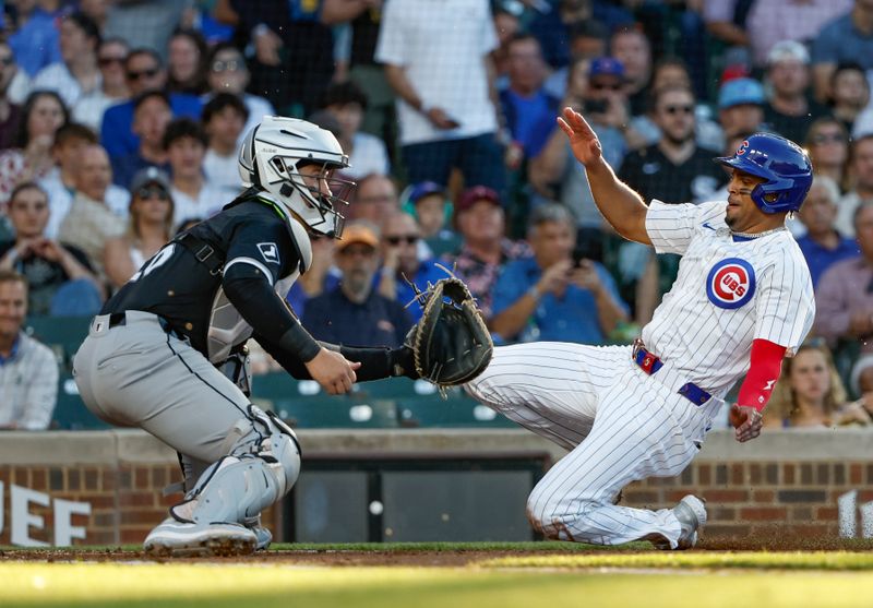 Jun 5, 2024; Chicago, Illinois, USA; Chicago Cubs third baseman Christopher Morel (5) slides to score as Chicago White Sox catcher Martín Maldonado (15) waits for the ball during the second inning at Wrigley Field. Mandatory Credit: Kamil Krzaczynski-USA TODAY Sports