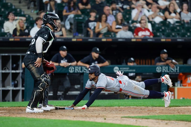 Jul 8, 2024; Chicago, Illinois, USA; Minnesota Twins outfielder Byron Buxton (25) slides to score against the Chicago White Sox during the 11th inning at Guaranteed Rate Field. Mandatory Credit: Kamil Krzaczynski-USA TODAY Sports