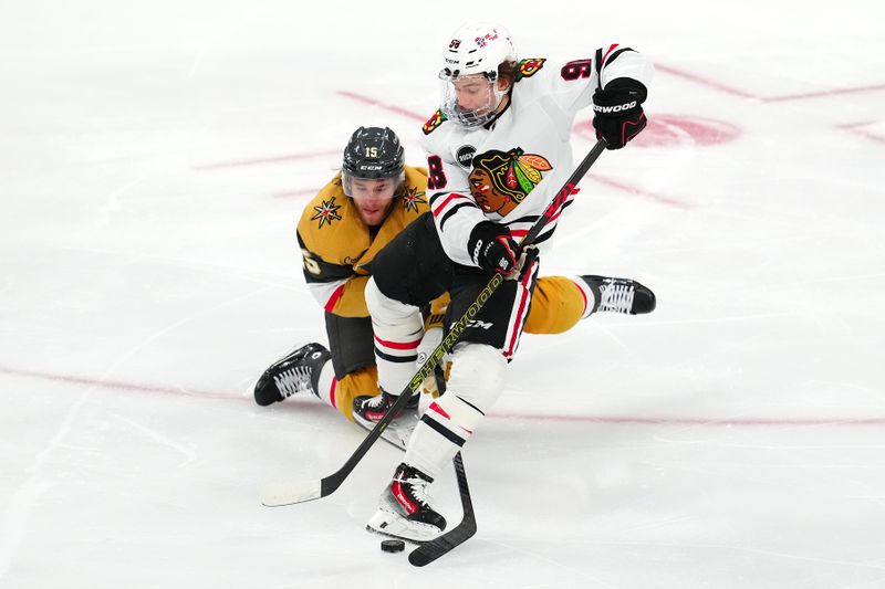 Apr 16, 2024; Las Vegas, Nevada, USA; Vegas Golden Knights defenseman Noah Hanifin (15) attempts to tip the puck away from Chicago Blackhawks center Connor Bedard (98) during the second period at T-Mobile Arena. Mandatory Credit: Stephen R. Sylvanie-USA TODAY Sports